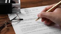 Woman signing Last Will and Testament at wooden table, closeup
