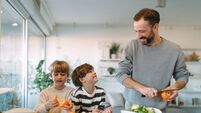 Father and his two young boys cooking a healthy meal together