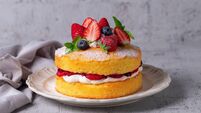Victoria sandwich cake, decorated with strawberries, blueberries and mint closeup