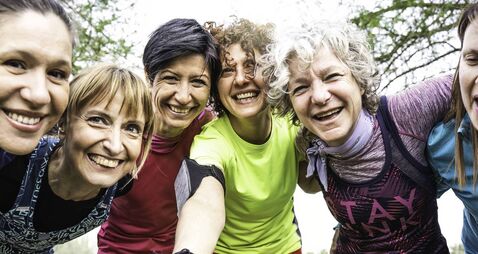 HER Outdoors group of women.jpg Happy multi generational women having fun together at city park - Multigenerational female friends taking selfie after sport wor