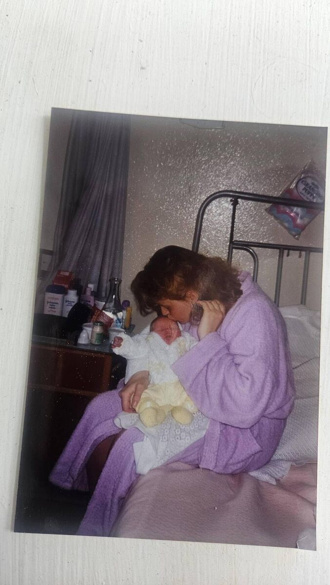 Nóra Flaherty cradling her baby daughter Aoife in St Finbarr's Hospital in May 1993. Aoife is wearing the yellow suit Nóra knitted for her in Bessborough.