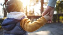 Close up of mother and a child hands at the sunset.