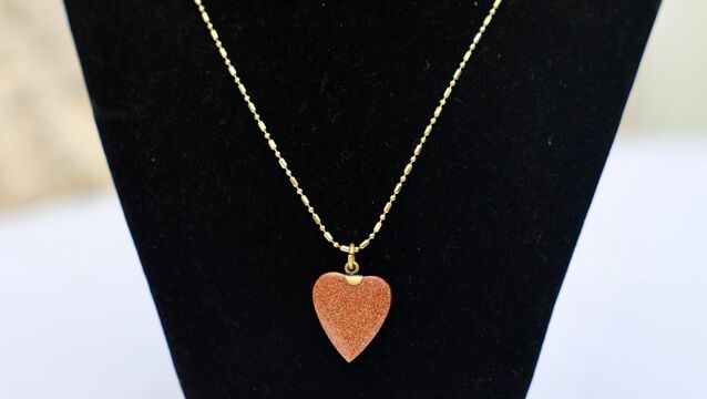 A sandstone heart-shaped pendant with a gold-plated chain. <p>A sandstone heart-shaped pendant with a gold-plated chain.</p>