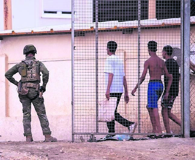Spanish army soldiers stand guard as migrants return to Morocco from Spain’s African territory of Ceuta on August 1. Picture: Antonio Sempere/AP Spanish army soldiers stand guard as migrants return to Morocco from Spain’s African territory of Ceuta on August 1. Picture: Antonio Sempere/AP