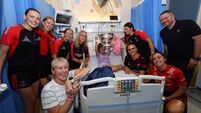 Meadhbh Enright with the O'Duffy Cup and her parents and the Cork team during the visit 10/8/2026
