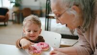 Little boy having snack with his grandmother.