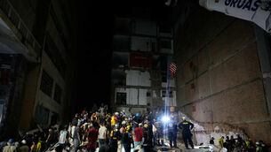 Rescue workers and residents search through the rubble after an earthquake struck Pereira, Colombia (Fernando Vergara/AP)