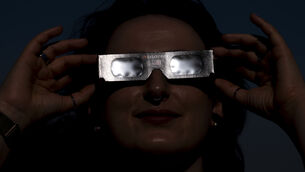 <p>Planetarium astronomer Dr Carys Herbert demonstrates wearing Celestron solar eclipse glasses (Jordan Pettitt/PA)</p>