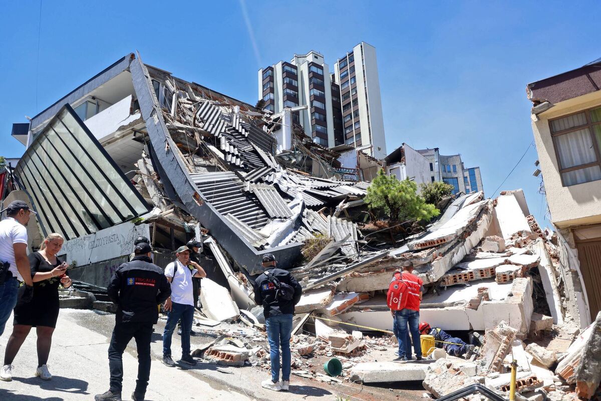People remain near a collapsed building after an earthquake in Manizales, Colombia, on Auguts 10, 2026. (Photo by Giovanny Galvez / AFP via Getty Images)