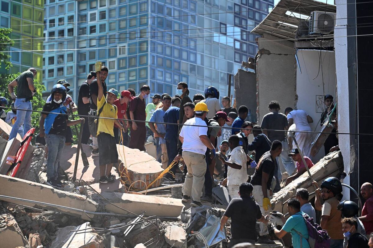 People look for survivors amid the rubble of a collapsed building after an earthquake in Cali, Colombia on August 10, 2026. (Photo by Joaquin SARMIENTO / AFP via Getty Images)