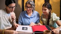 iStock-2284726026.jpg Two Women and Teenager Girl Reviewing Family Photo Album