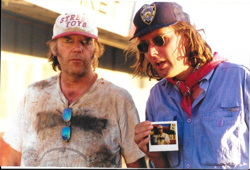 Neil Young, with painted-on eyes, and Tim Pope on a shoot in 1997. Picture: Robert Bray