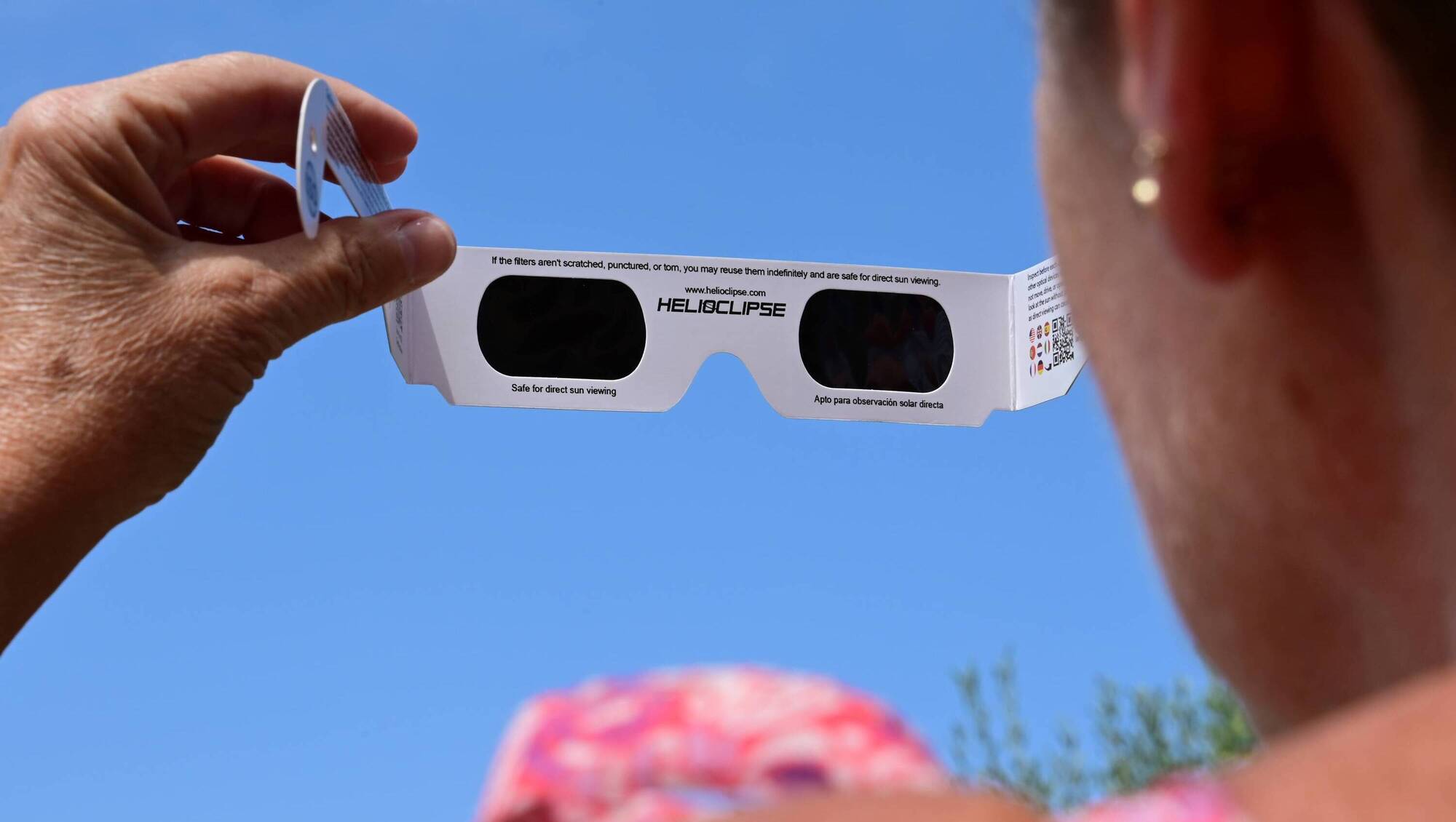 A woman uses solar eclipse glasses for the total solar eclipse of August 12, 2026. Picture: Romain Doucelin / Hans Lucas.