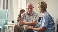 Smiling retired man with female home carer