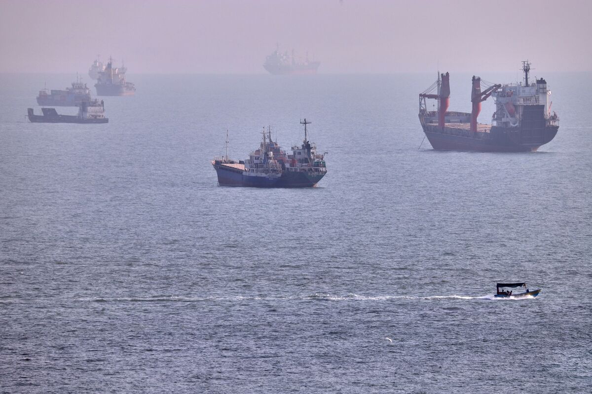 A small boat sails past cargo ships and other commercial vessels anchored in the Strait of Hormuz off Bandar Abbas, Iran, Wednesday, Aug. 5, 2026. (Amirhosein Khorgooi/ISNA via AP)