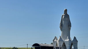 People gather near an enormous statue of the Virgin Mary (Claudia Ciobanu/AP)