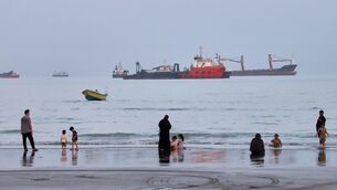 Families are seen on a beach as vessels are anchored in the Strait of Hormuz in the background off Bandar Abbas, Iran (Amirhosein Khorgooi/ISNA/AP) Families are seen on a beach as vessels are anchored in the Strait of Hormuz in the background off Bandar Abbas, Iran (Amirhosein Khorgooi/ISNA/AP)