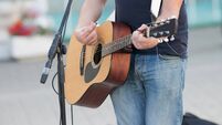 Anonymous man playing guitar on the street, street musician