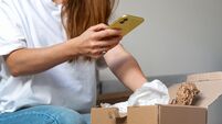 Express delivery. Receiving online purchase. Woman unpacking cardboard and taking pictures of purchases.