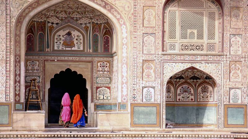 Women walking amidst the intricate buildings of Jaipur's Amber Fort Women walking amidst the intricate buildings of Jaipur's Amber Fort