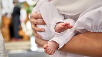 The legs of a newborn during baptism in the church. Baptism and anointing ceremony.