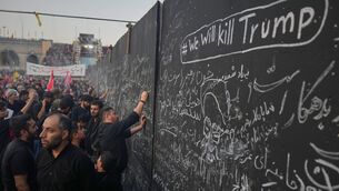 <p>Mourners write messages on a wall, including one in English that reads "We will kill Trump," during the funeral ceremonies for slain Iranian Supreme Leader Ayatollah Ali Khamenei and members of his family at the Imam Khomeini Mosalla Grand Mosque in Tehran, Iran. (AP Photo/Altaf Qadri)</p>