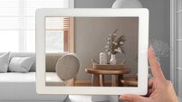 Augmented reality concept. Hand holding tablet with AR application used to simulate furniture products in custom architecture de