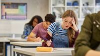 Student girl feeling stressed during exam at secondary school