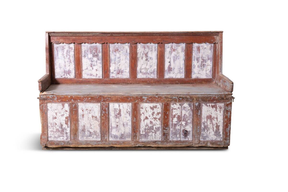 A red-and-white painted three-seater settle bench at James Adam. A red-and-white painted three-seater settle bench at James Adam.