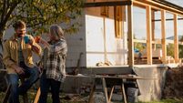 Mature couple having coffee break when working together on construction site of their new house.