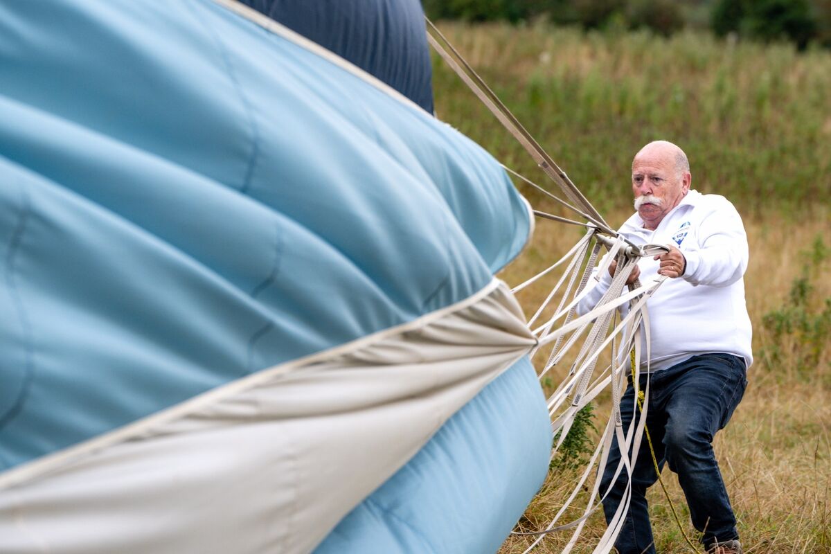 Joe Daly wrestles with the huge canvas of the Discover Waterford balloon as he helps deflate it after landing. Picture: Chani Anderson Joe Daly wrestles with the huge canvas of the Discover Waterford balloon as he helps deflate it after landing. Picture: Chani Anderson