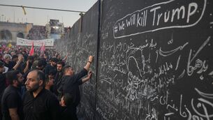 <p>Mourners write messages on a wall, including one in English that reads "We will kill Trump," during the funeral ceremonies for slain Iranian Supreme Leader Ayatollah Ali Khamenei. (AP Photo/Altaf Qadri)</p>