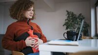 Young woman having menstrual cramp problems while working from home