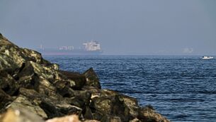 Cargo ships are seen at sea in the Gulf of Oman near the Strait of Hormuz (Fatima Shbair/AP)