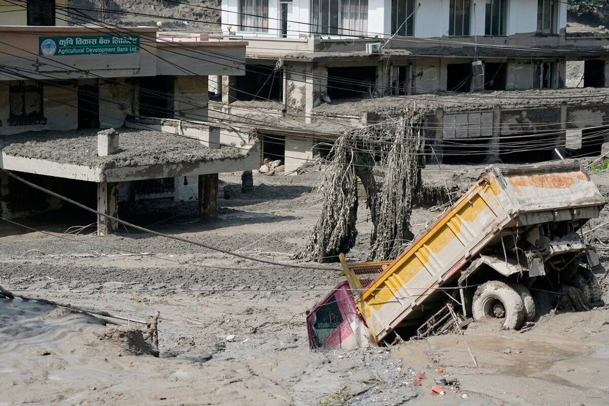 Damaged houses and vehicles are seen in the aftermath of flash floods along the Trishuli River in Nepal's Nuwakot district, Wednesday, Aug. 26, 2026. (AP Photo/Niranjan Shrestha)