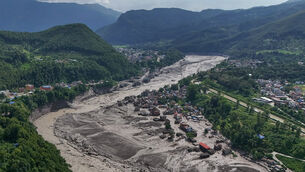 <p>Damaged houses stand near the swollen, debris-choked banks of the Trishuli River after flash floods in Nepal’s Nuwakot district (Niranjan Shrestha/AP)</p>
