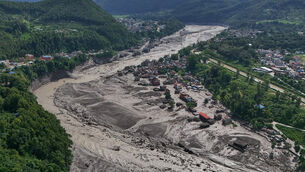 <p>Damaged houses stand near the swollen, debris-choked banks of the Trishuli River after flash floods in Nepal’s Nuwakot district (Niranjan Shrestha/AP)</p>