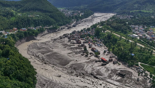 <p>Damaged houses stand near the swollen, debris-choked banks of the Trishuli River after flash floods in Nepal’s Nuwakot district (Niranjan Shrestha/AP)</p>