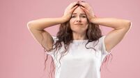 Woman having headache. Isolated over pink background.