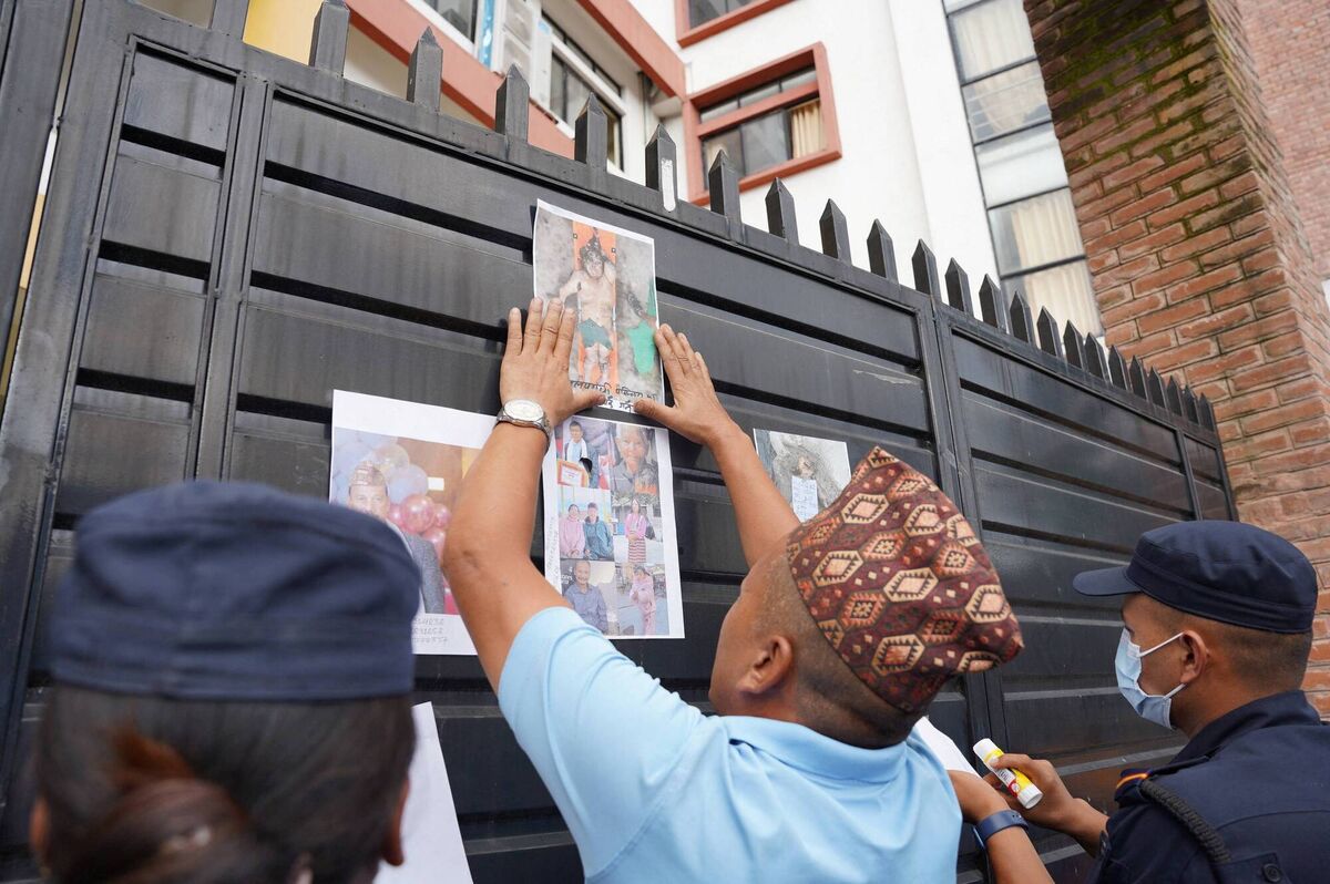 Men paste photographs of victims, who died in flash floods and mudslides, on a gate for identification outside a mortuary in Kathmandu, Nepal, August 27, 2026. REUTERS/Sabrina Dangol