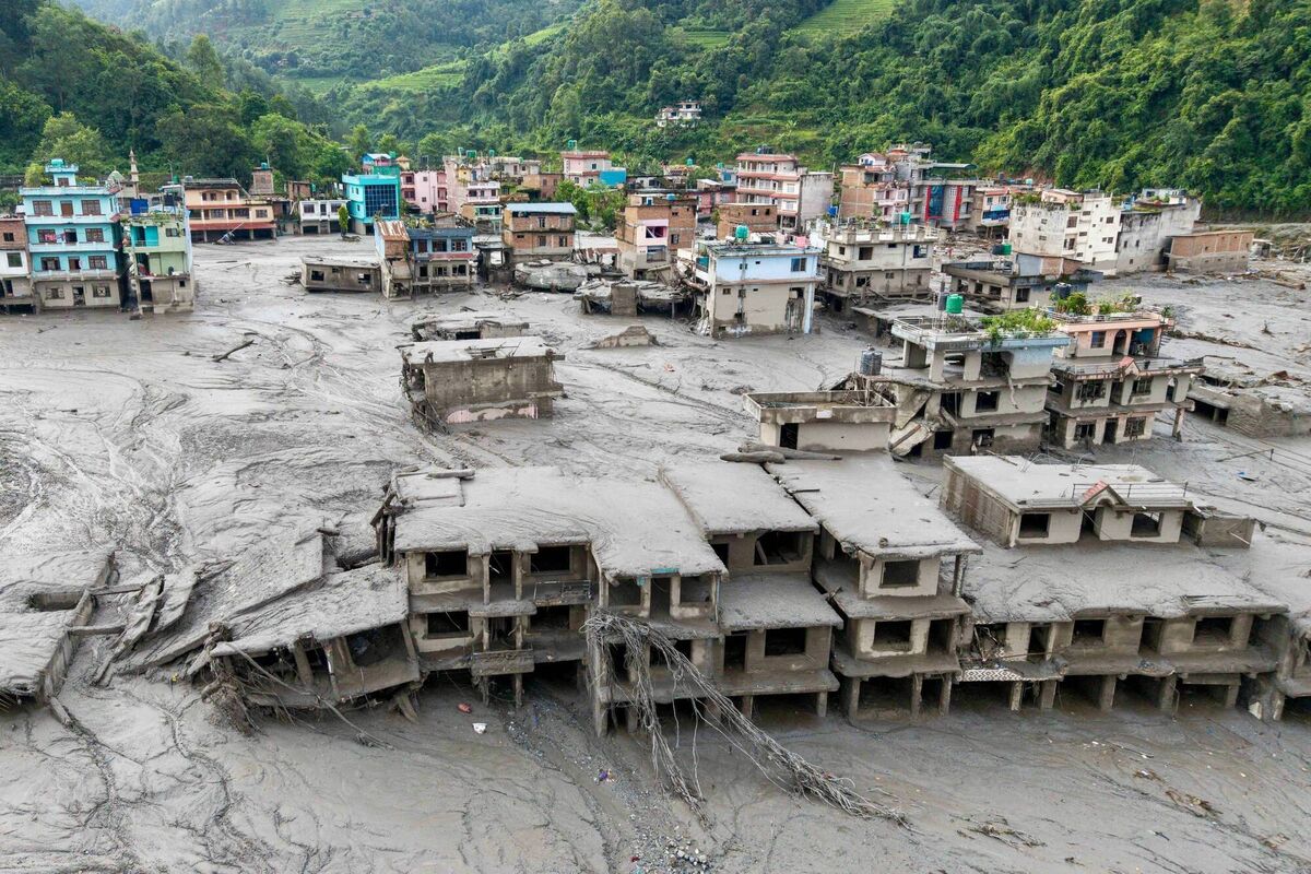 An aerial view shows houses lying deluged in sludge after flash floods at Devighat, Bidur Municipality in Nepal's Nuwakot district on August 27, 2026. Nepal's disaster agency said that 823 people remained out of contact on August 27, more than 24 hours after a deadly flood tore through the border region with Tibet. (Photo by Prabin RANABHAT / AFP via Getty Images)
