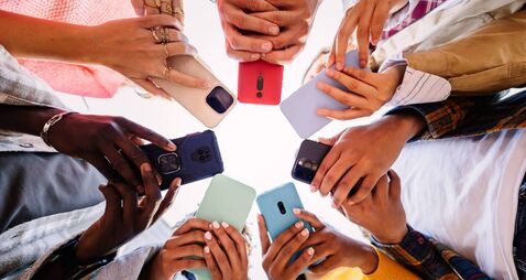 Young group of student people using smartphone together outside