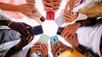 Young group of student people using smartphone together outside