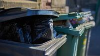 Overfull garbage cans wheelie bins close up