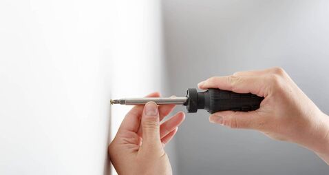 Worker manually tightening hang screw