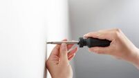 Worker manually tightening hang screw