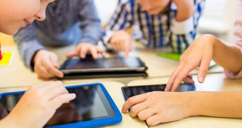 close up of school kids playing with tablet pc