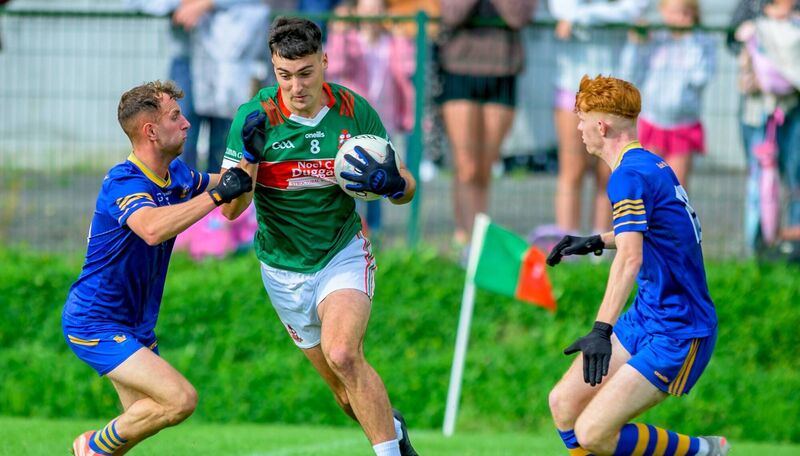 Kilcummin's Paul O'Shea under pressure from Ballymac's Daire Keane and Jack Joy in Saturday's Kerry IFC quarter final at Kilcummin. Pic: Seamus Healy