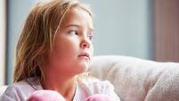 Physically Abused Child At Home Sitting On Sofa