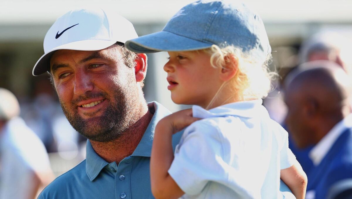 Scottie Scheffler holds his child Bennett after winning the Tour Championship. Pic: Colin Hubbard/AP
